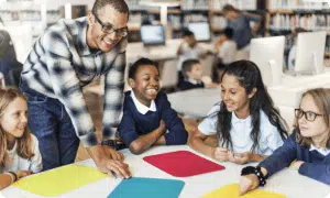 Male teacher working with students at a table