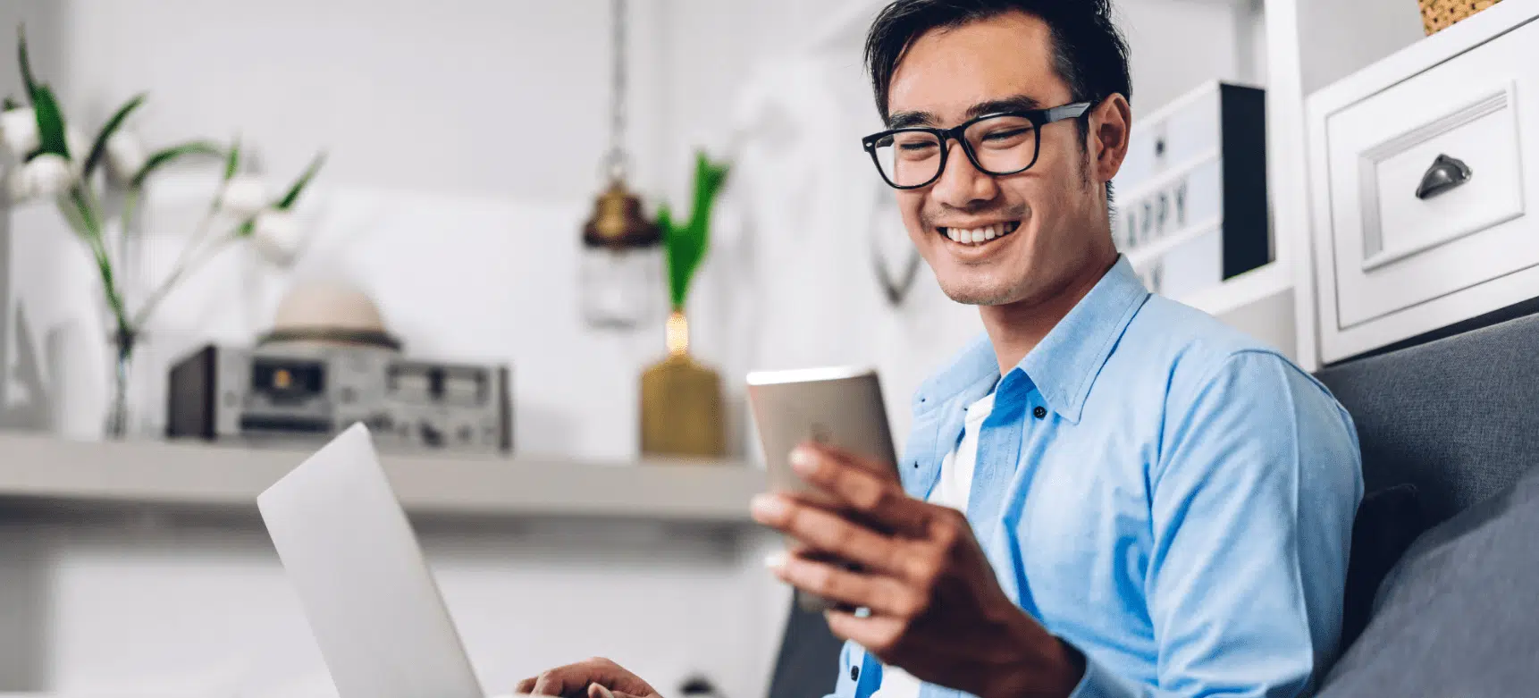 Young smiling Asian man looking at a cell phone