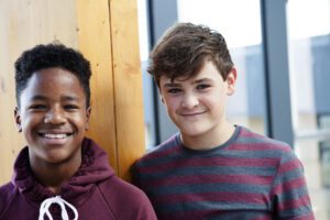 Portrait of two teenage schoolboys in corridor