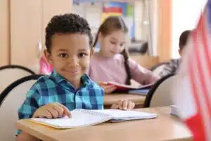 Elementary-aged boy smiling at desk