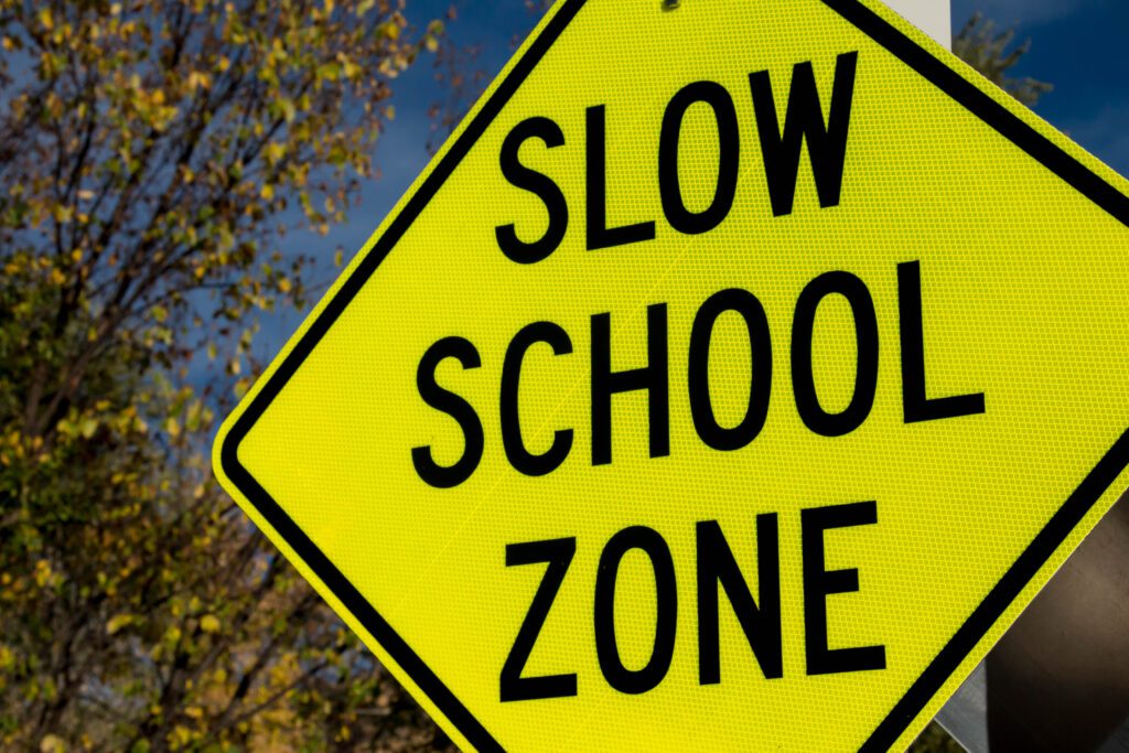 Yellow sign reading, "Slow School Zone"