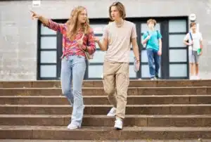 Teen boy and girl walking down school steps