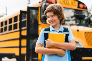 Smiling boy getting off a school bus
