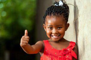 Young black girl smiling and giving a thumbs-up
