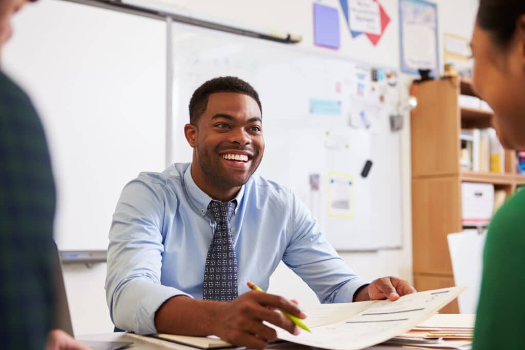Teacher smiling at a desk