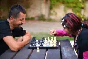 Man and girl playing chess outside