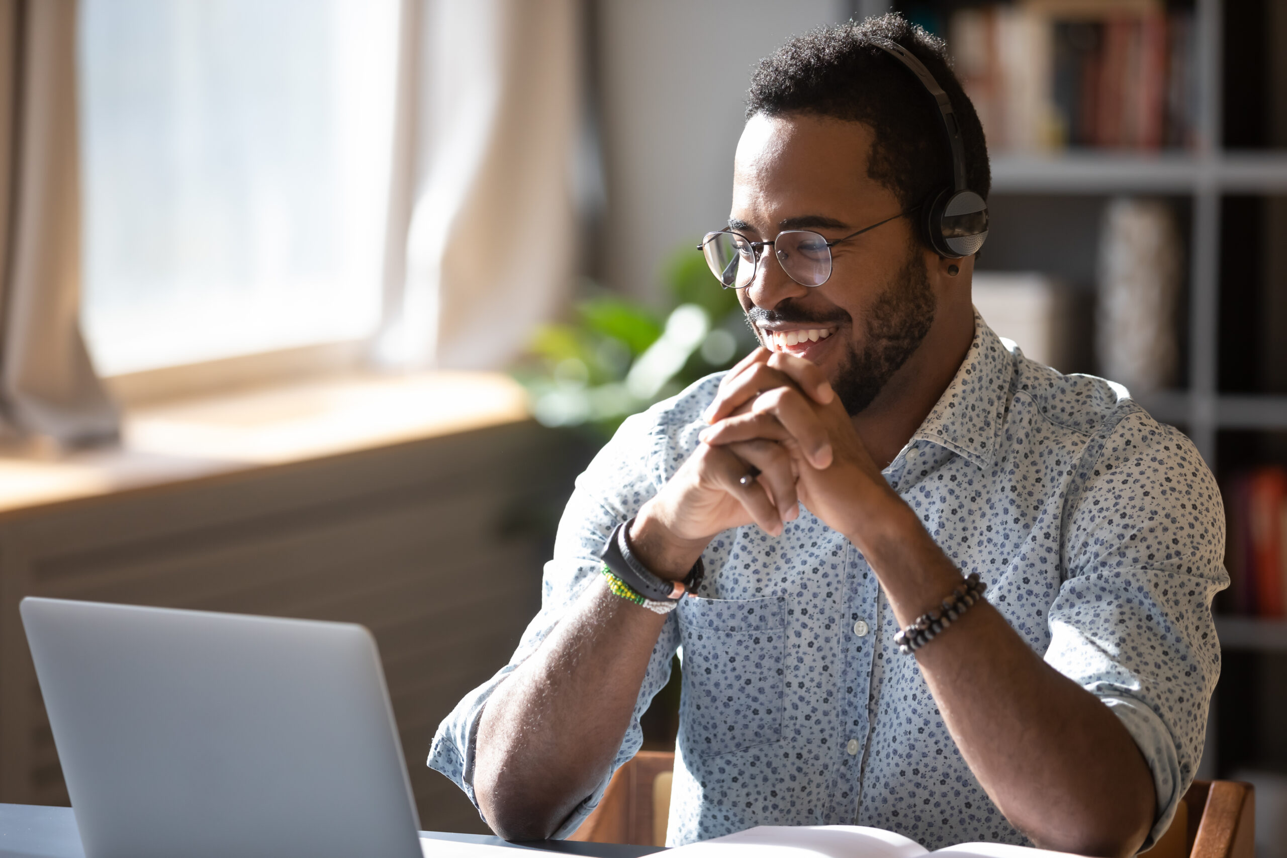 Man smiling while looking at a laptop