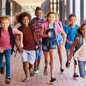 Group of smiling students running into school